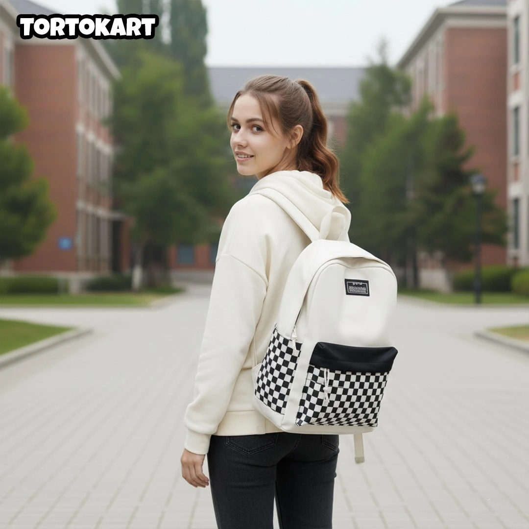 young woman with a high ponytail walking on a university path wearing a white and black checkerboard backpack