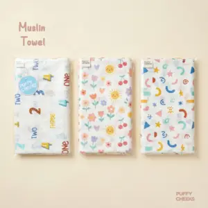 Small square soft yellow Puffy Cheeks muslin towel made of 100% cotton layered fabric, displayed on a neutral background with a decorative dried flower branch.