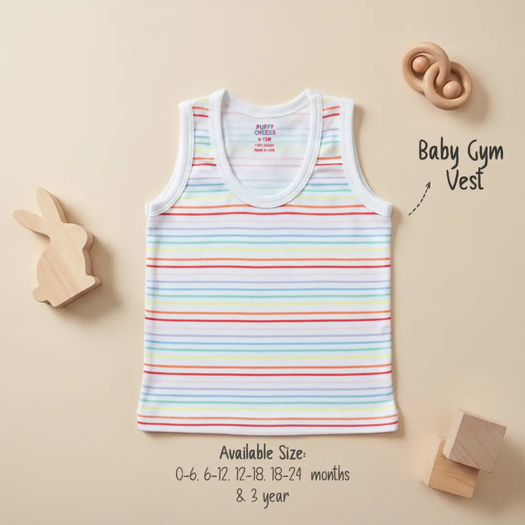 Puffy Cheeks white baby gym vest with blue trim featuring an all-over nautical print of anchors and sailboats, displayed on a neutral background with wooden blocks and toys.
