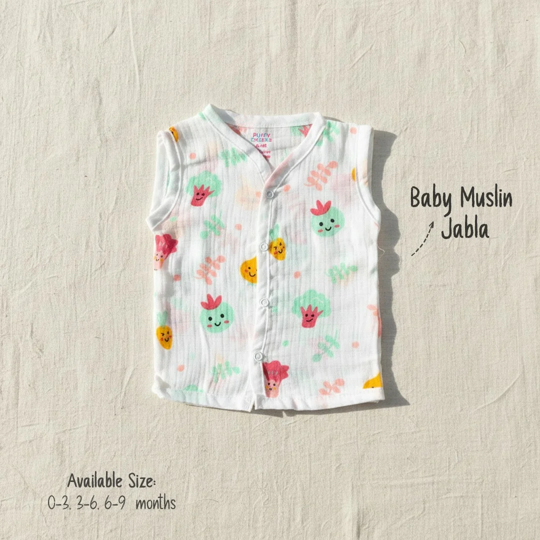 Sleeveless white muslin jabla for babies by Puffy Cheeks featuring smiling broccoli and carrot illustrations.