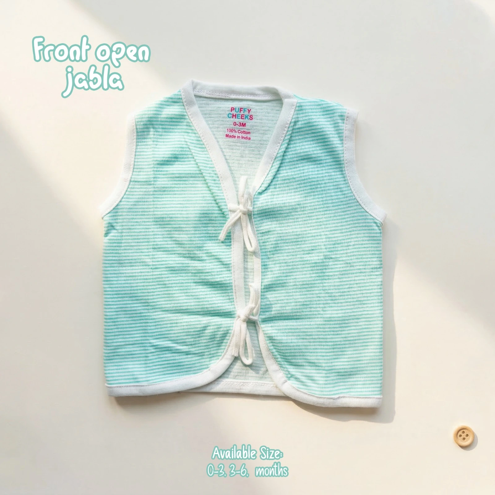 The image named WhatsApp Image 2026-06-17 at 12.51.45 PM (1).jpg shows a sleeveless, front-open baby jabla by Puffy Cheeks featuring an all-over pattern of thin, horizontal mint green and white micro-stripes. The garment is designed with a v-neckline, soft white fabric piping along all borders, and two fabric tie-front closures at the center, flat-laid on a clean cream surface with a small wooden button nearby.
