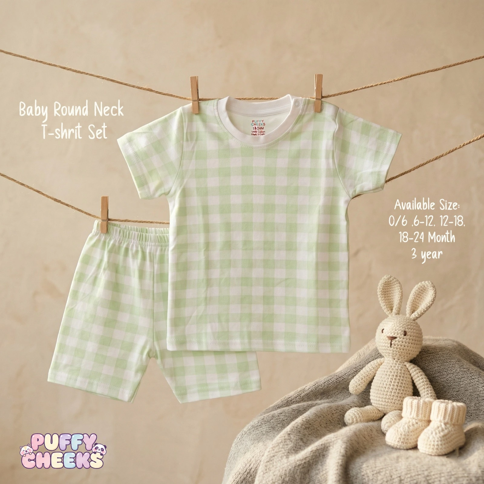 Baby round neck t-shirt and shorts set by Puffy Cheeks featuring a mint green and white gingham check pattern on soft cotton fabric, with the short-sleeve t-shirt showing a solid white crew neck collar and a left-shoulder snap button, hanging from a clothesline with wooden pegs next to matching elastic-waist check shorts, displayed above a soft knit blanket draped with small knit infant booties and a plush knit bunny toy.